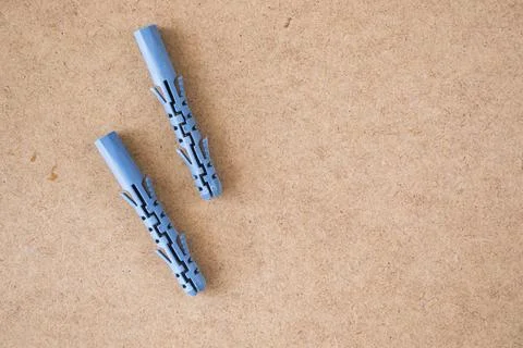 Blue plastic wall plugs on the brown background Stock Photos
