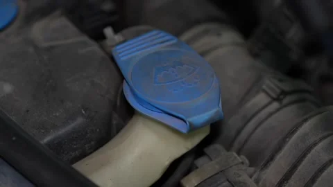 Blue plastic windshield washer fluid reservoir cap in car engine. Stock Footage 344595759