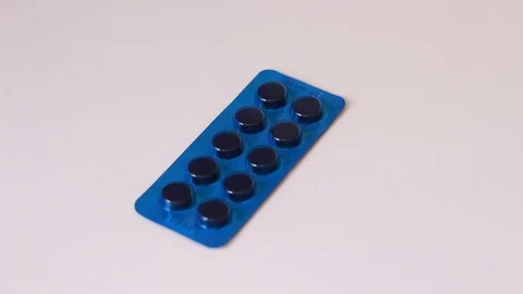 Blue plate with pills on white surface Stock Footage 86894422