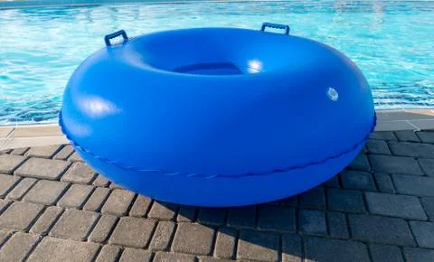 Blue pool float, ring floating lying by the refreshing swimming pool. Empty r Stockfoto's