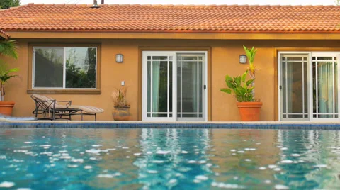 Blue pool water surface next to a generic house exterior. Stock Footage 38932618