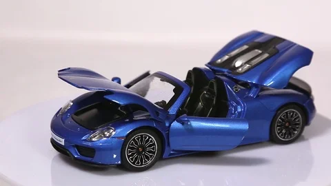 Blue Porsche 918 scale model sports car with opened doors and hood Stock Footage 101794145