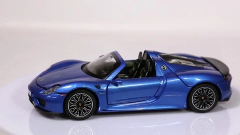 Blue Porsche 918 scale model sports car is rotating isolated on white Stock-Footage 101794148