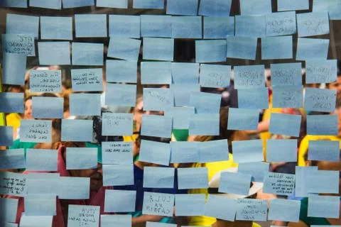 Blue post-it sticky notes on a glass wall. Stock-Fotos