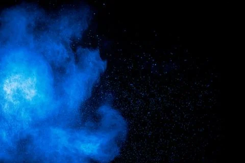 Blue powder explode cloud on black background.Launched blue dust particles. Stock Photos