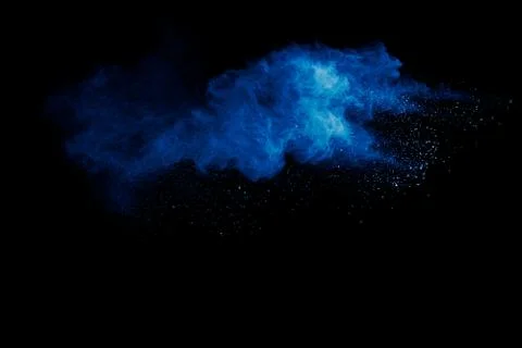 Blue powder explode cloud on black background.Launched blue dust particles. Stock Photos