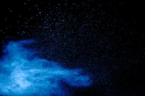 Blue powder explode cloud on black background.Launched blue  dust particles. 스톡 사진