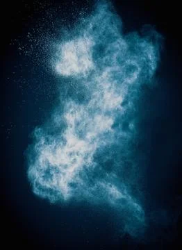 Blue powder exploding isolated on black Foto stock