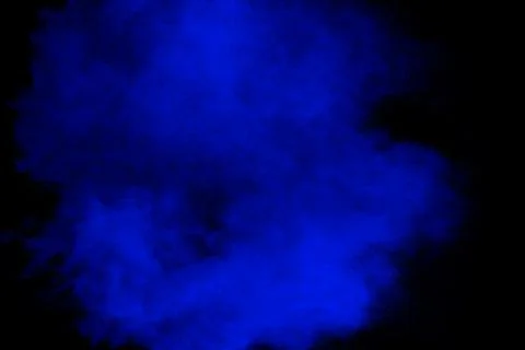 Blue powder explosion cloud on black background.Launched blue dust particle. Stock Photos
