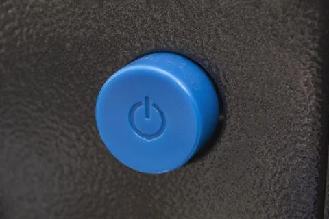 Blue power button on an electronic device Stock Photos