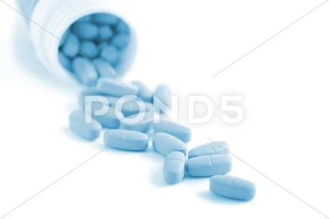 Blue prescription pills falling out of bottle isolated Stock Photos