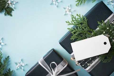 Blue present boxes with empty gift tag on light blue background. Space for yo Stock Photos