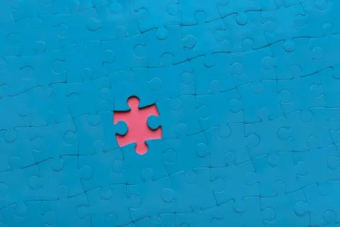 Blue puzzle with one missing piece on a blue background Stock Photos