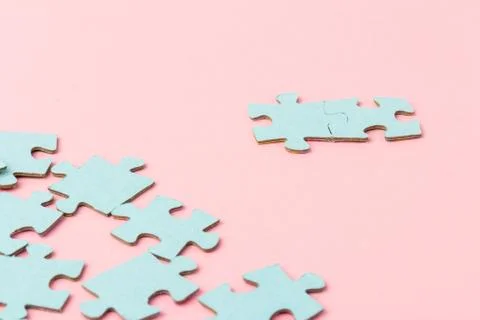 Blue puzzle pieces with empty space for your text and design on pink backgrou Stock Photos