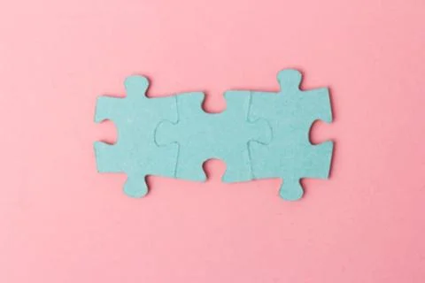Blue puzzle pieces with empty space for your text and design on pink backgrou Stock Photos