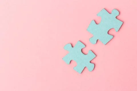Blue puzzle pieces with empty space for your text and design on pink backgrou Stock Photos