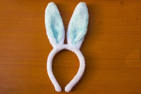 Blue rabbit ear headband placed on a brown table Stock Photos