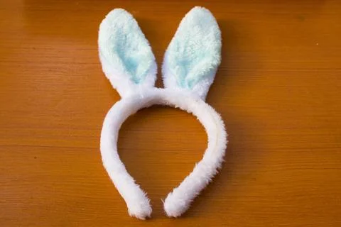 Blue rabbit ear headband placed on a brown table Stock Photos