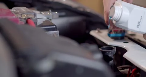 The blue radiator water.Adding Coolant to Car radiators or Pouring antifreeze. Stock Footage 270576794