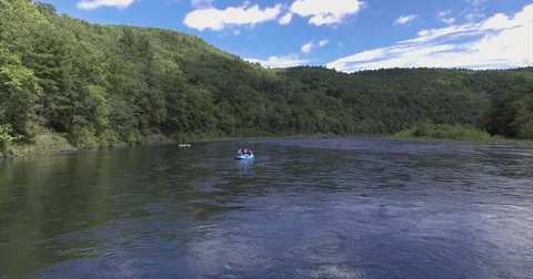 Blue raft on a broad temperate river between wooded hills Stock-Footage 71262378