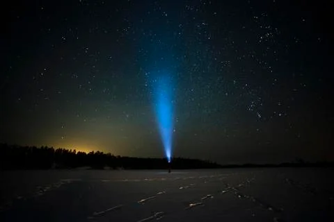 Blue ray of flashlight in the starry sky Stock Photos