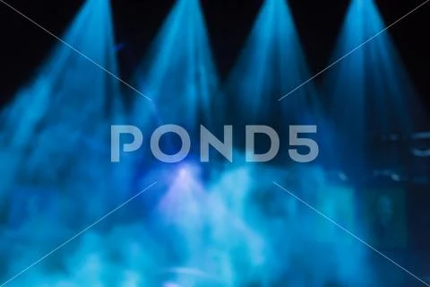 Blue rays of light from the spotlights through the smoke on the stage Stock Photos