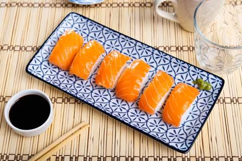 Blue rectangular ceramic plate of delicious salmon nigiri with soy souse on 스톡 사진