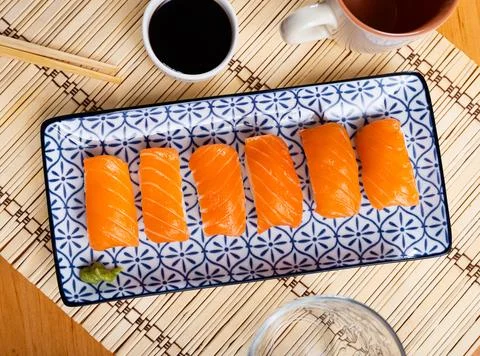 Blue rectangular ceramic plate of delicious salmon nigiri with soy souse on Foto stock