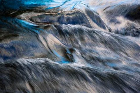 Blue reflection of the sky on a flowing river Stock Photos