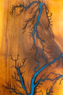 Blue resin river pattern in polished wood surface with lightning grain detail Stock Photos