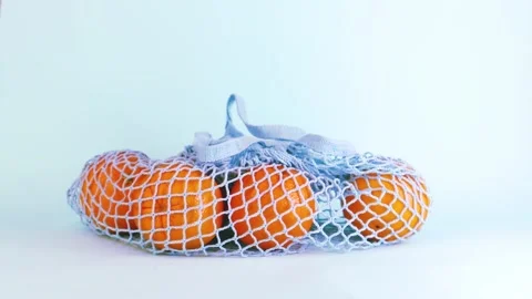 A blue reusable bag with oranges put on a table on a blue background. Stock Footage 168668183