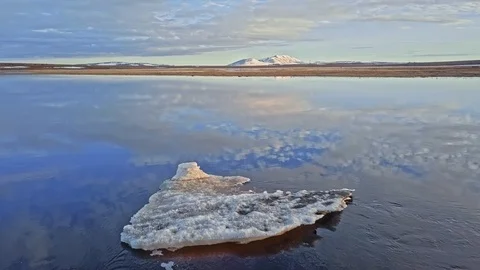 Blue river with drifting ice piece and cloudy sky reflection Stock Footage 124455662