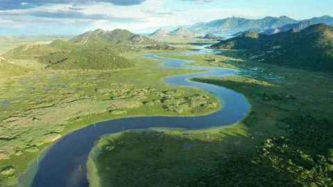 Blue river flowing through green valley toward distant mountains Stock Footage 132607957