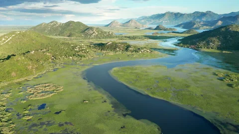 Blue river flowing through green valley toward distant mountains Stock Footage 132609915