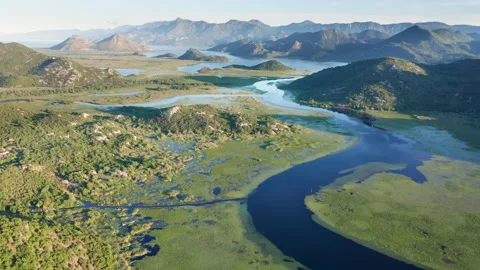 Blue river flowing through green valley toward distant mountains Stock Footage 132622875