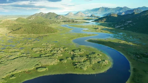 Blue river flowing through green valley toward distant mountains Stock Footage 132625439