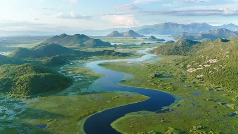 Blue river flowing through green valley toward distant mountains Stock Footage 133421152