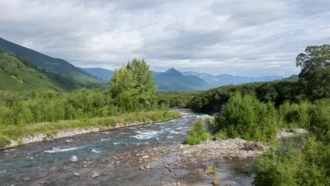 Blue river flows under an azure sky. A sunny summer day. Kamchatka 스톡 사진