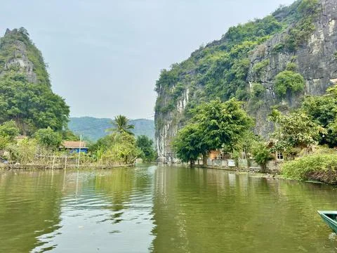 Blue river winding between vertical limestone mountains at the famous Tam Coc Stock Photos