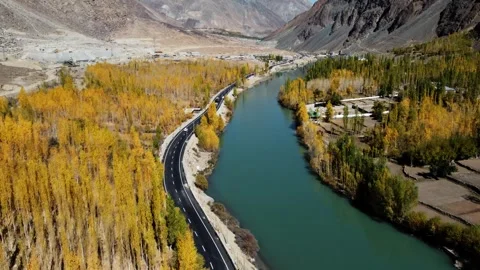 Blue river winding through golden Himalayan trees caught on drone. Stock Footage 310782180