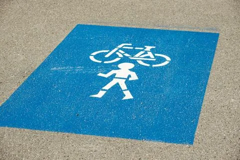 Blue road marking indicating a shared pedestrian and bicycle lane on the asph Stock Photos