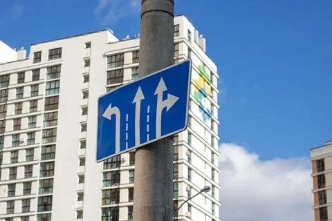 Blue road sign with arrow pointers closeup Stock Photos