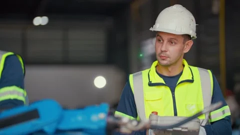 Blue robotic arm moves precisely in factory setting 库存影片 344919425