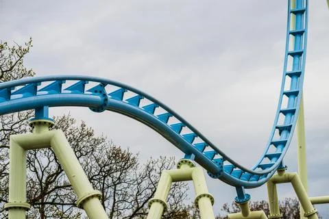 Blue roller coaster track against cloudy sky. Stock Photos
