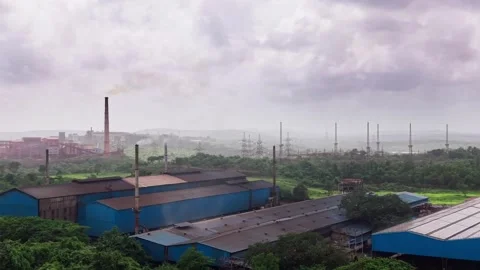 Blue roofed manufacturing plant surrounded by misty forested hills in monsoon Stock Footage 340975036