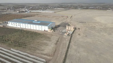Blue-roofed warehouse in the field 1 Stock Footage 330802905