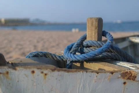 Blue rope on old boat to the shore of the sea. Stock Photos