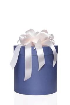 Blue round box with a white bow on an isolated white background. Stock Photos