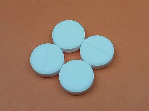 Blue round tablets on brown background Stock Photos