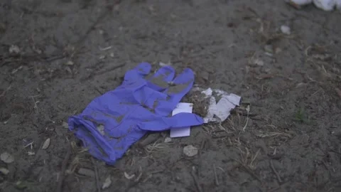 Blue rubber glove left in the dirty ground pollution Stock Footage